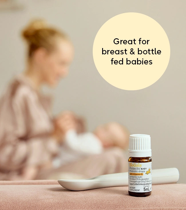 Mother feeding baby – BioGaia Protectis Baby Probiotic Drops placed nearby, ideal for breast- and bottle-fed infants.